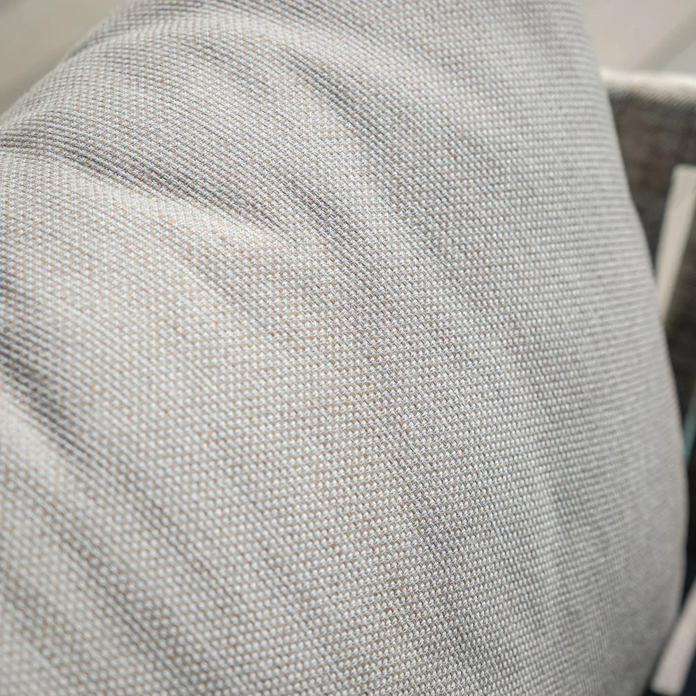 Close-up of light grey sofa cushion with textured upholstery fabric