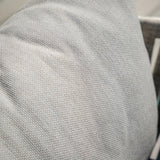 Close-up of light grey sofa cushion with textured upholstery fabric