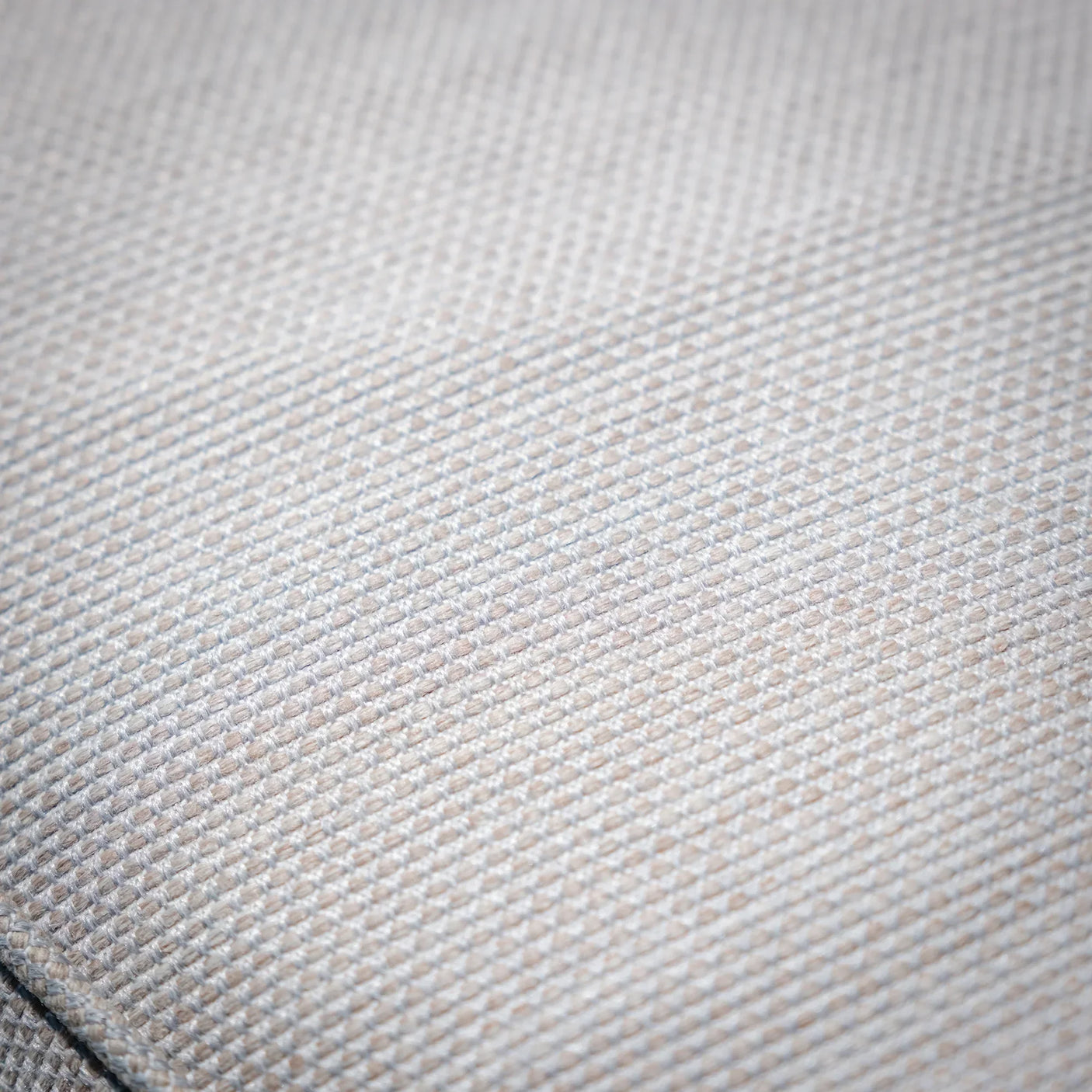Closeup of light beige sofa fabric texture with subtle woven pattern