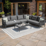 Grey outdoor corner sofa set with cushions and coffee table on patio rug