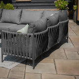 Grey outdoor corner sofa with rope back detail on patio