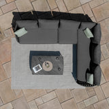 Grey corner outdoor sofa set with cushions and coffee table on patio tiles