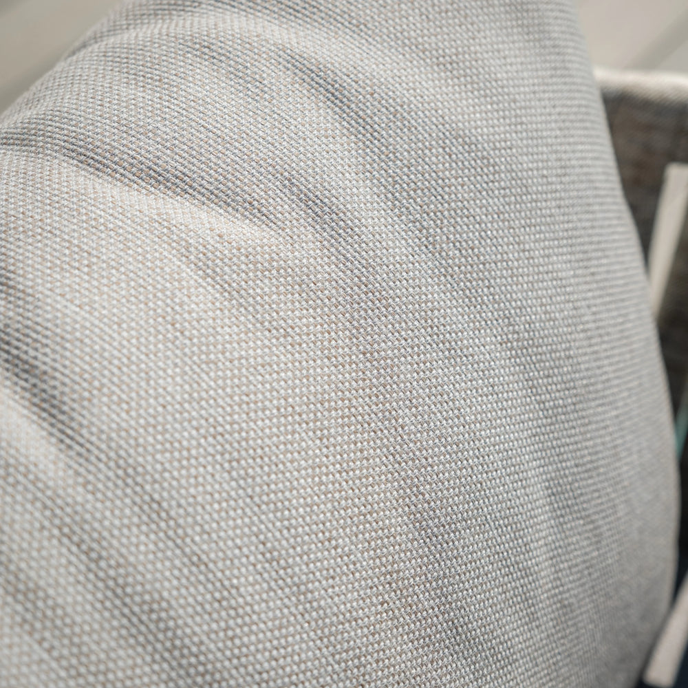Close up of light grey woven fabric cushion on sofa