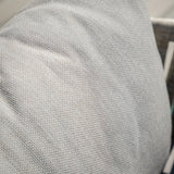 Close up of light grey woven fabric cushion on sofa