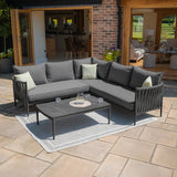 Grey outdoor corner sofa set with cushions and coffee table on patio