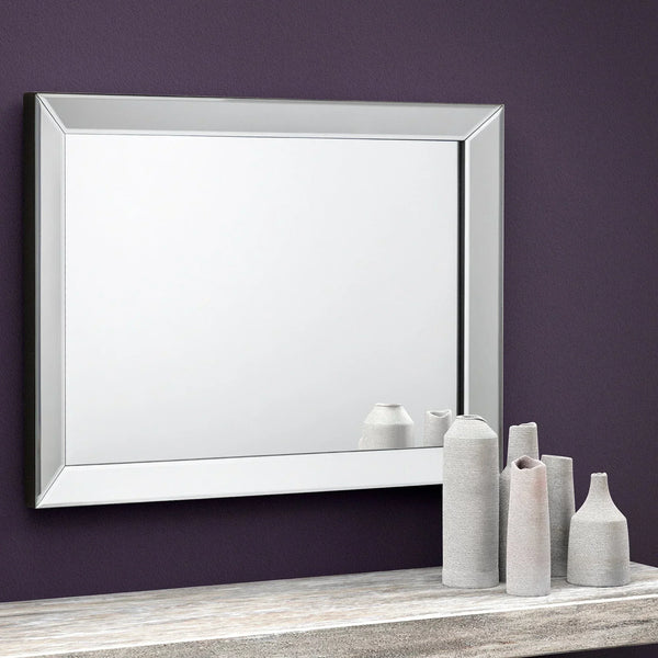 Soprano wall mirror with beveled edge above console table and ceramic vases on purple wall