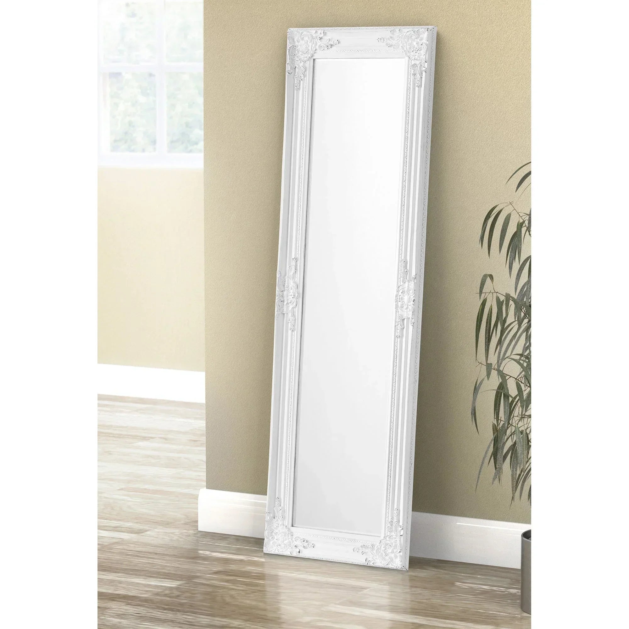 Palais white dress mirror with ornate frame leaning against beige wall in bright room