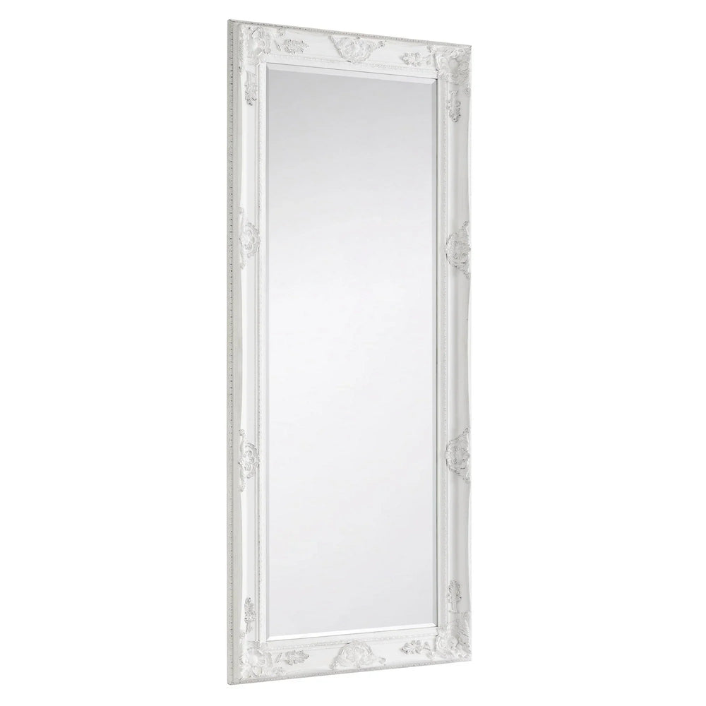 White ornate dress mirror with decorative carved frame, shown at an angled side view