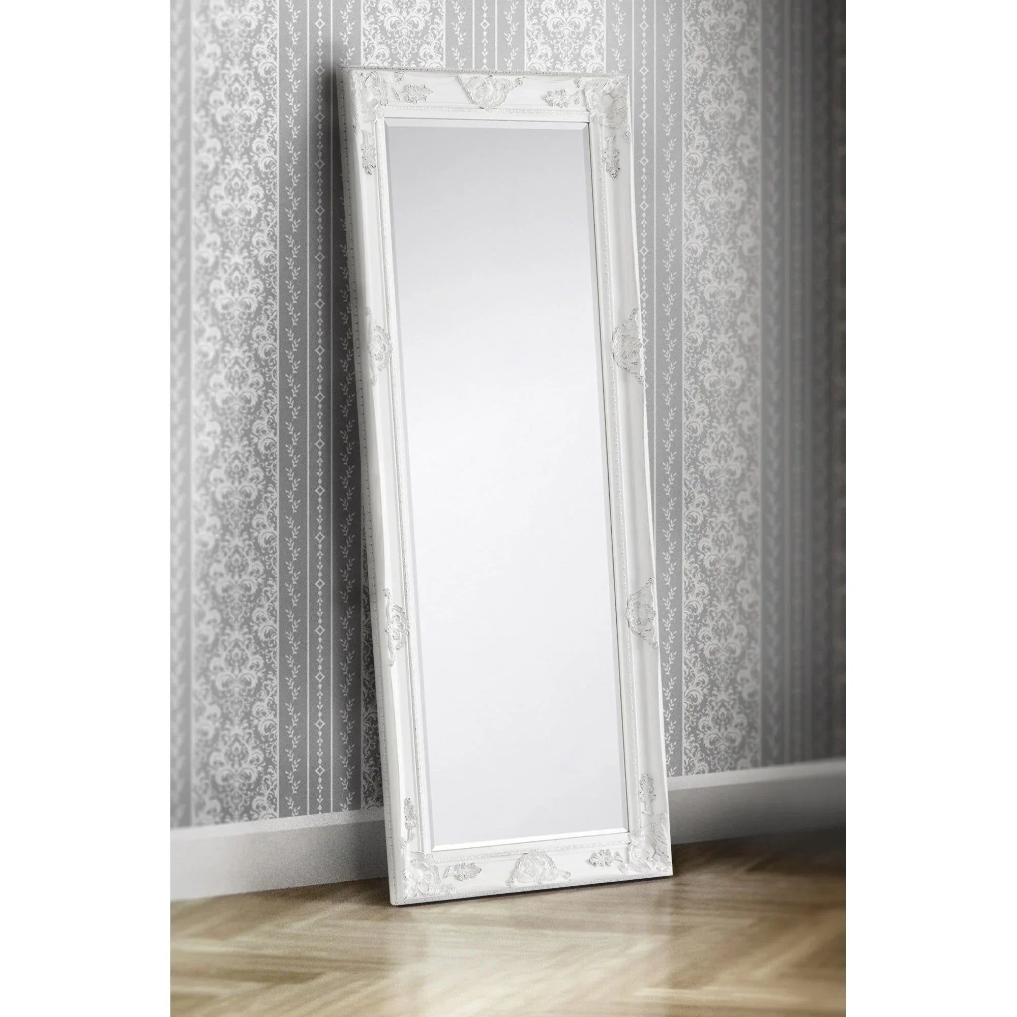 White lean to dress mirror with ornate frame against patterned grey wall and wood floor