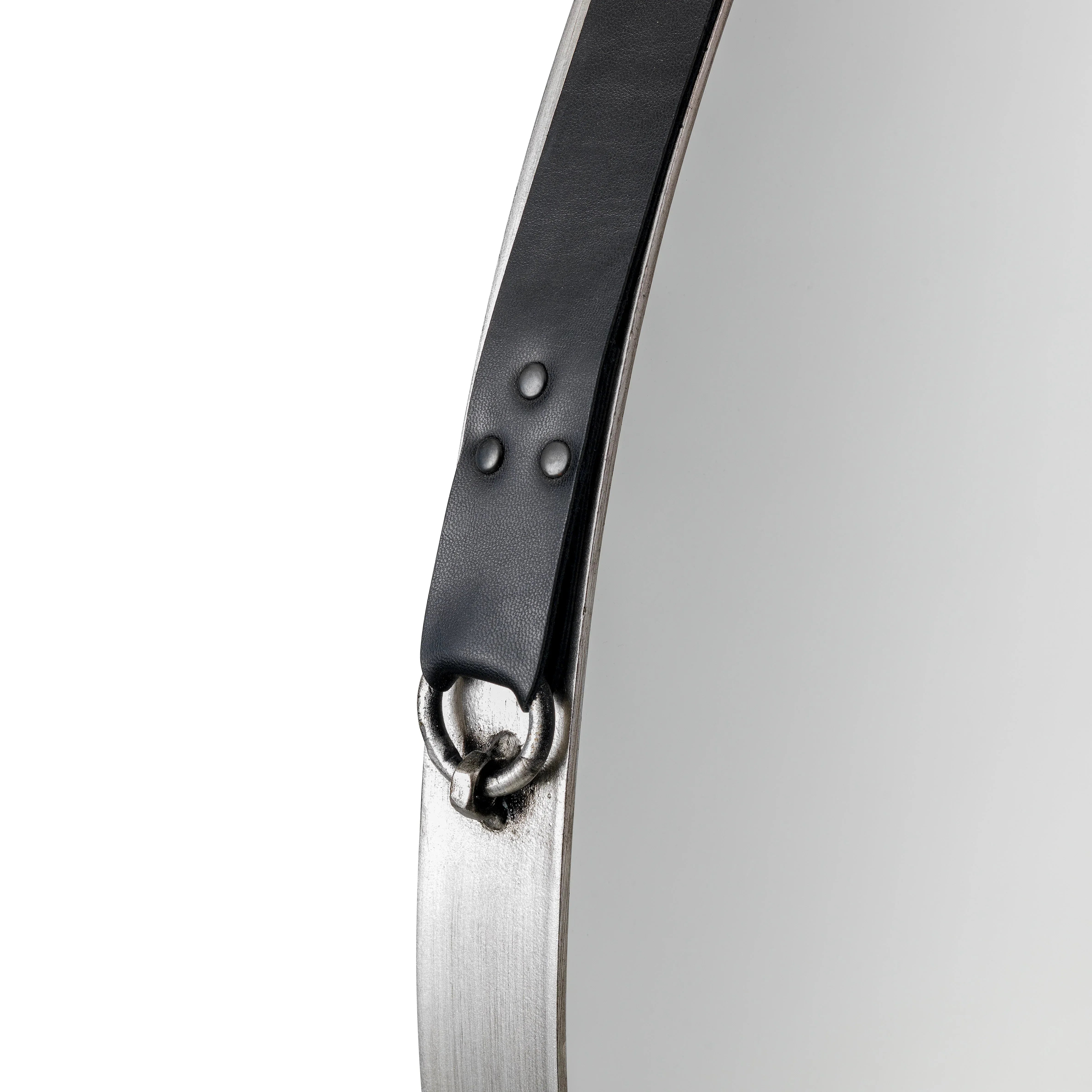 Round wall mirror with metal frame and black leather hanging strap detail close-up