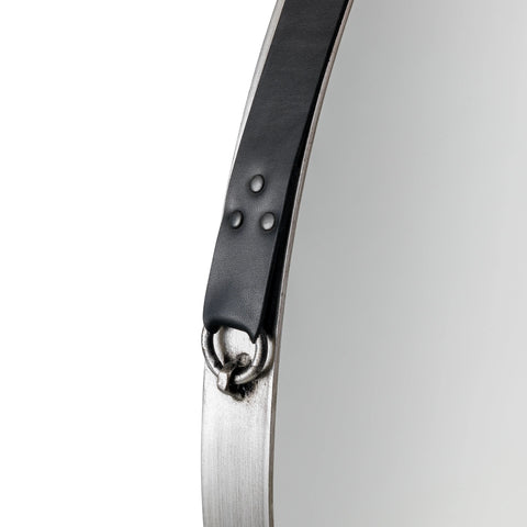 Round wall mirror with metal frame and black leather hanging strap detail close-up