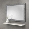 Rectangular wall mirror with decorative silver textured frame above a white floating shelf