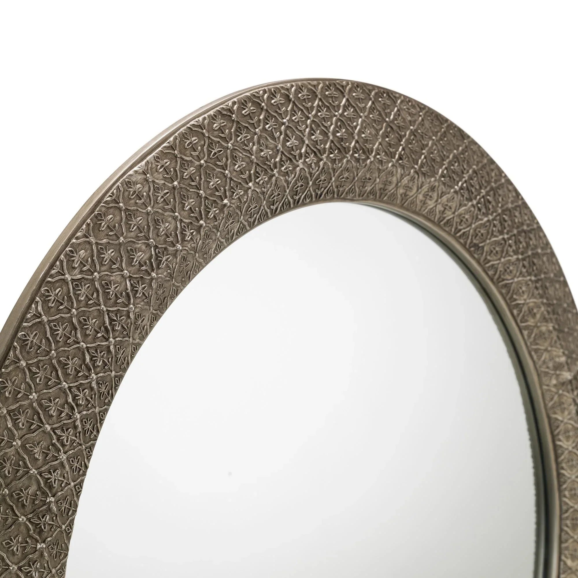 Round wall mirror with embossed metallic frame and floral pattern detailing