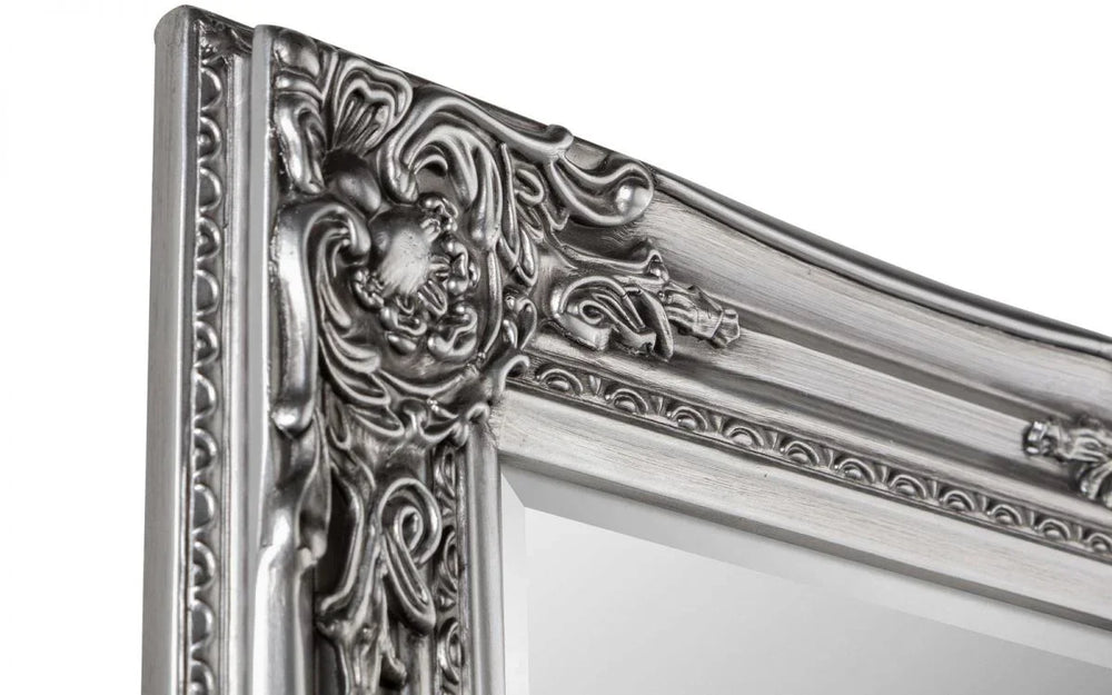Silver ornate mirror frame with intricate floral detailing, close-up view of corner