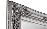 Silver ornate mirror frame with intricate floral detailing, close-up view of corner