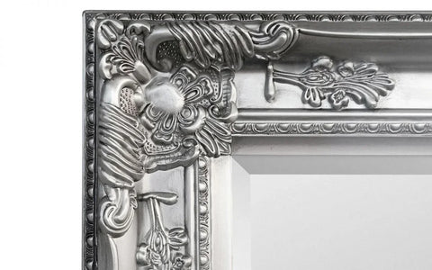 Close-up of ornate silver mirror frame corner with floral and scroll detail