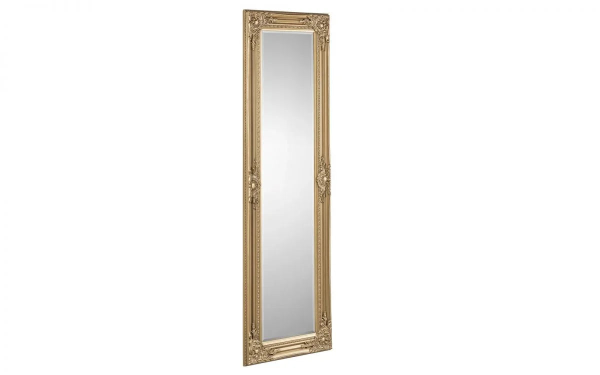 Tall gold ornate framed mirror with decorative detailing shown at an angle
