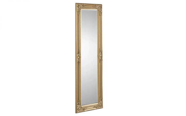 Tall gold ornate framed mirror with decorative detailing shown at an angle