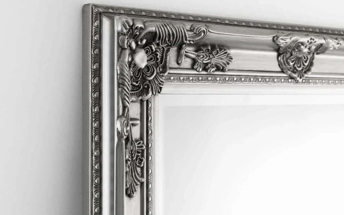 Silver ornate wall mirror with detailed floral frame corner close-up