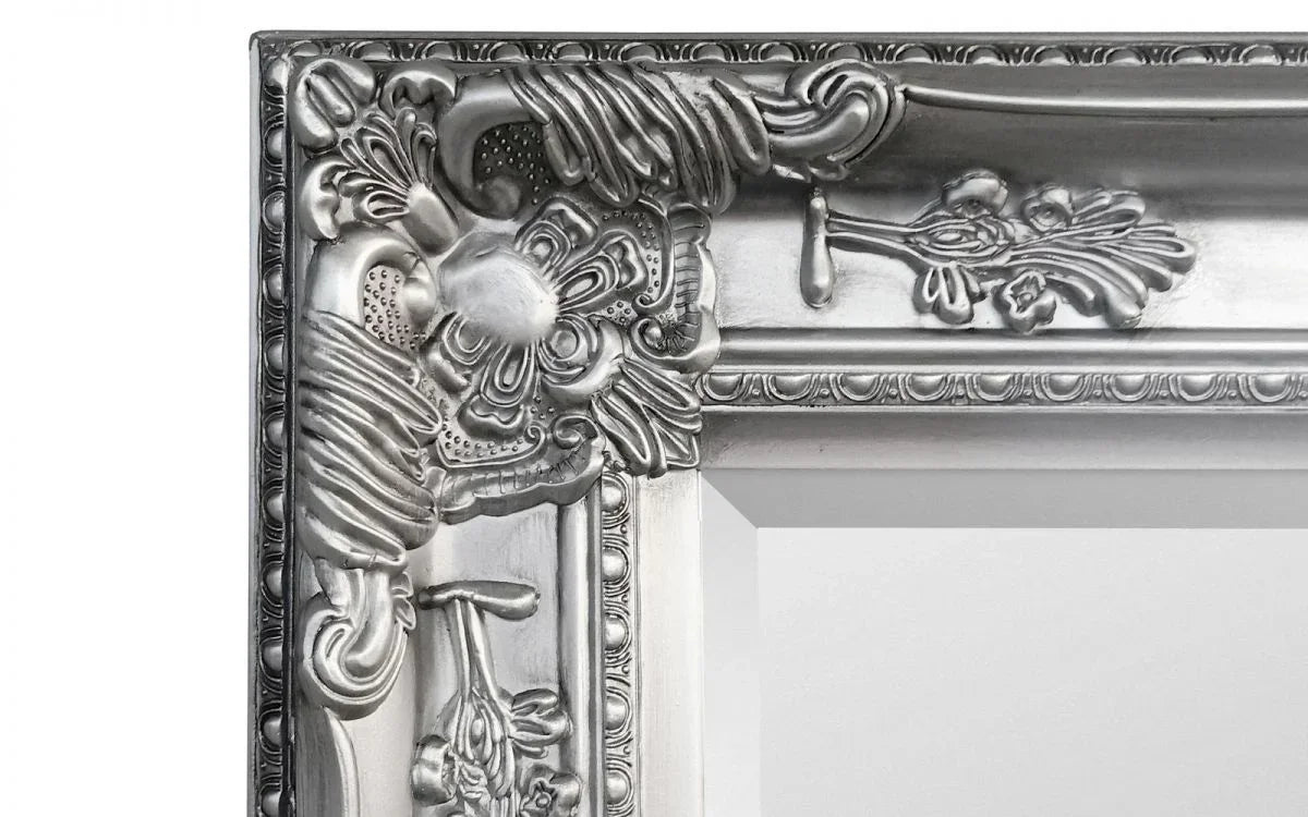 Close-up of silver ornate mirror frame with floral detailing and embossed edges