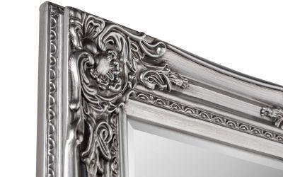 Silver ornate mirror frame with decorative scrollwork, close-up of corner detailing