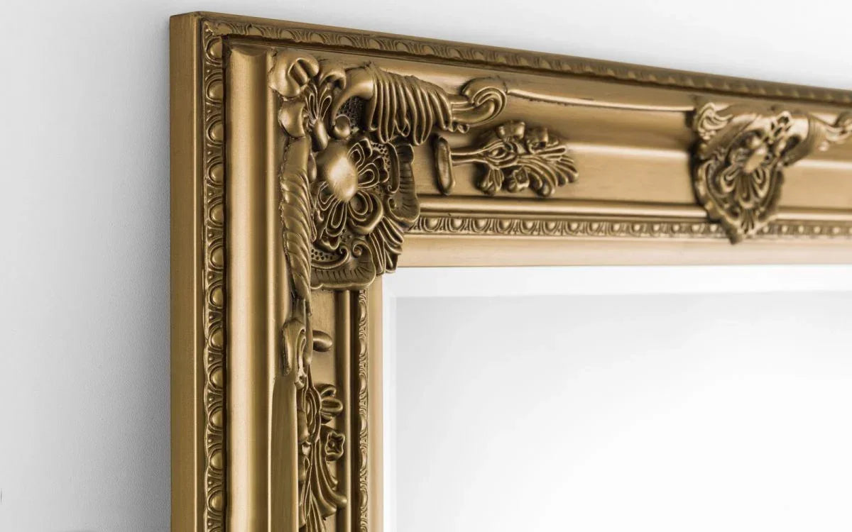 Close up of ornate gold wall mirror frame with floral decorative detailing