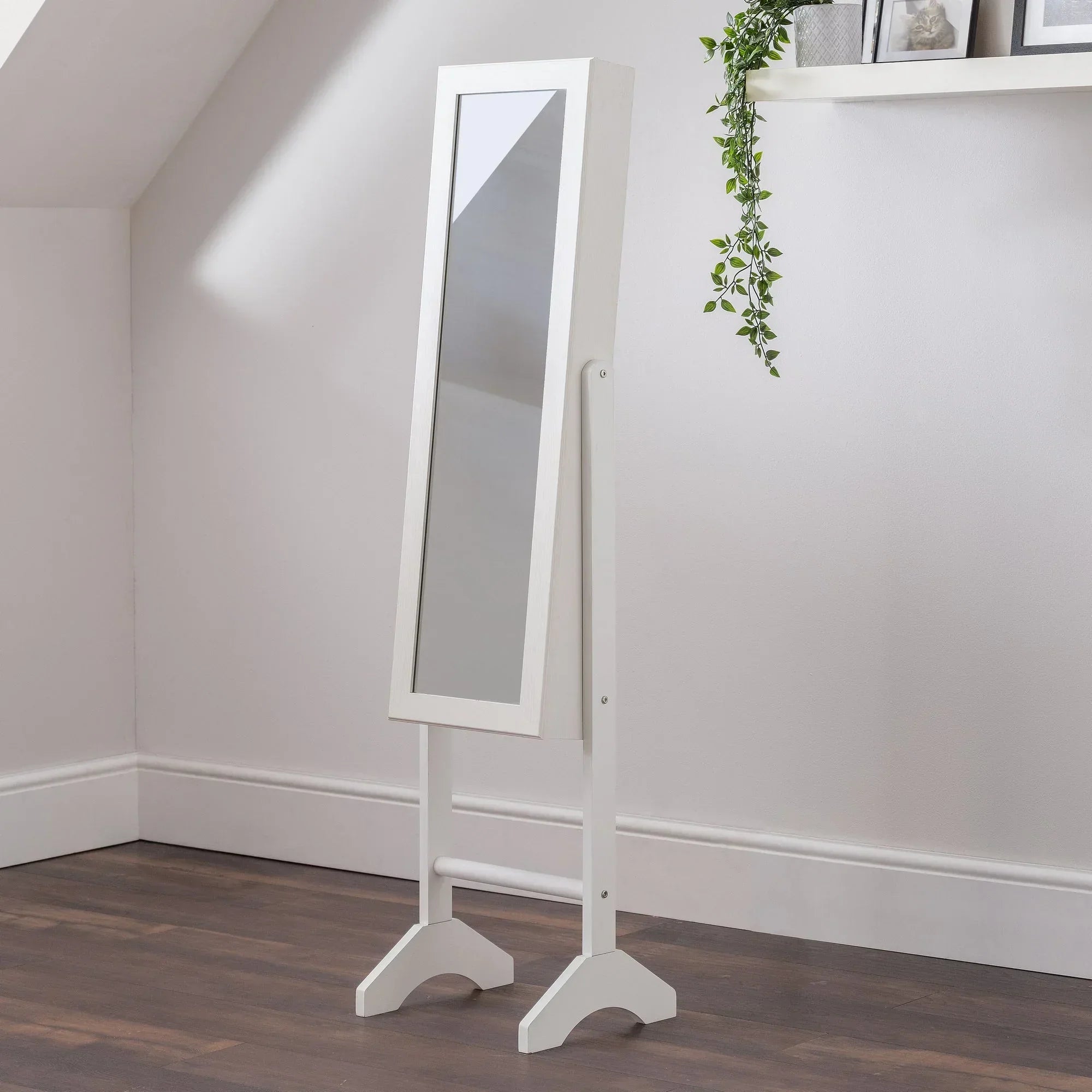White jewellery mirror with tilting frame on wooden floor in modern bedroom corner