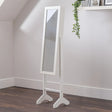 White jewellery mirror with tilting frame on wooden floor in modern bedroom corner