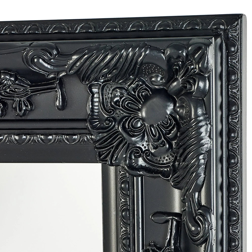 Close-up of ornate black mirror frame with detailed floral and scrollwork design