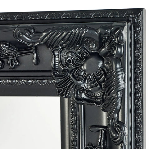 Close-up of ornate black mirror frame with detailed floral and scrollwork design