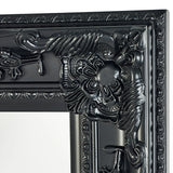 Close-up of ornate black mirror frame with detailed floral and scrollwork design
