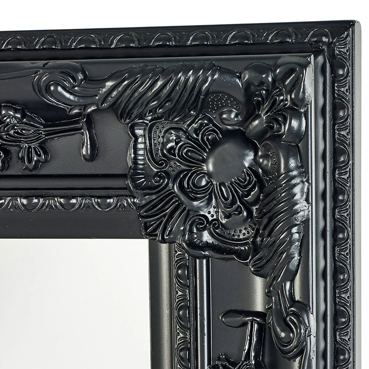 Close-up of ornate black mirror frame with detailed floral and scrollwork design