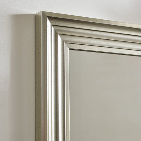 Silver wall mirror with bevelled edge frame against white background