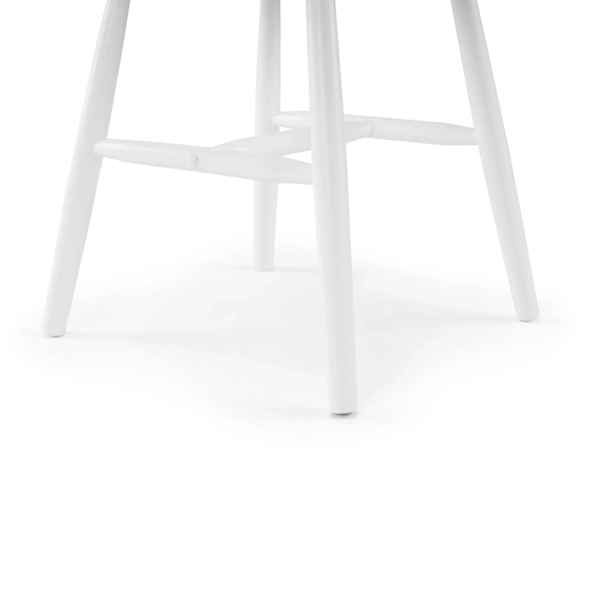 Closeup of white wooden dining chair legs and cross supports on white background
