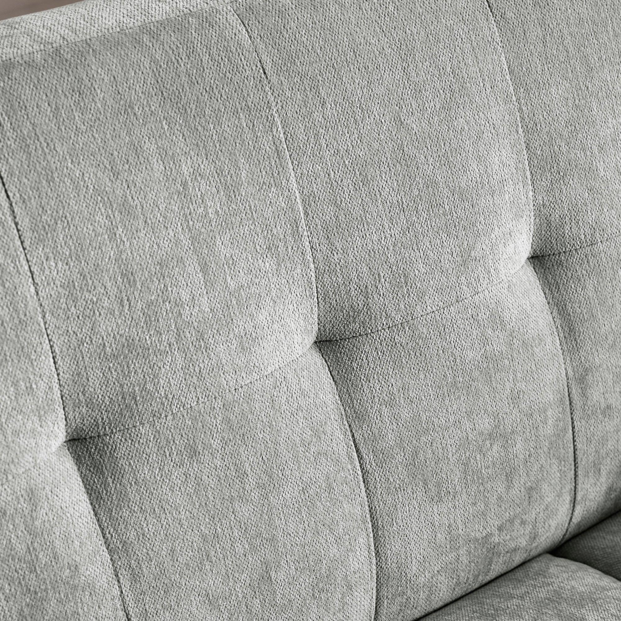 Grey fabric sofa backrest with square tufted stitching detail
