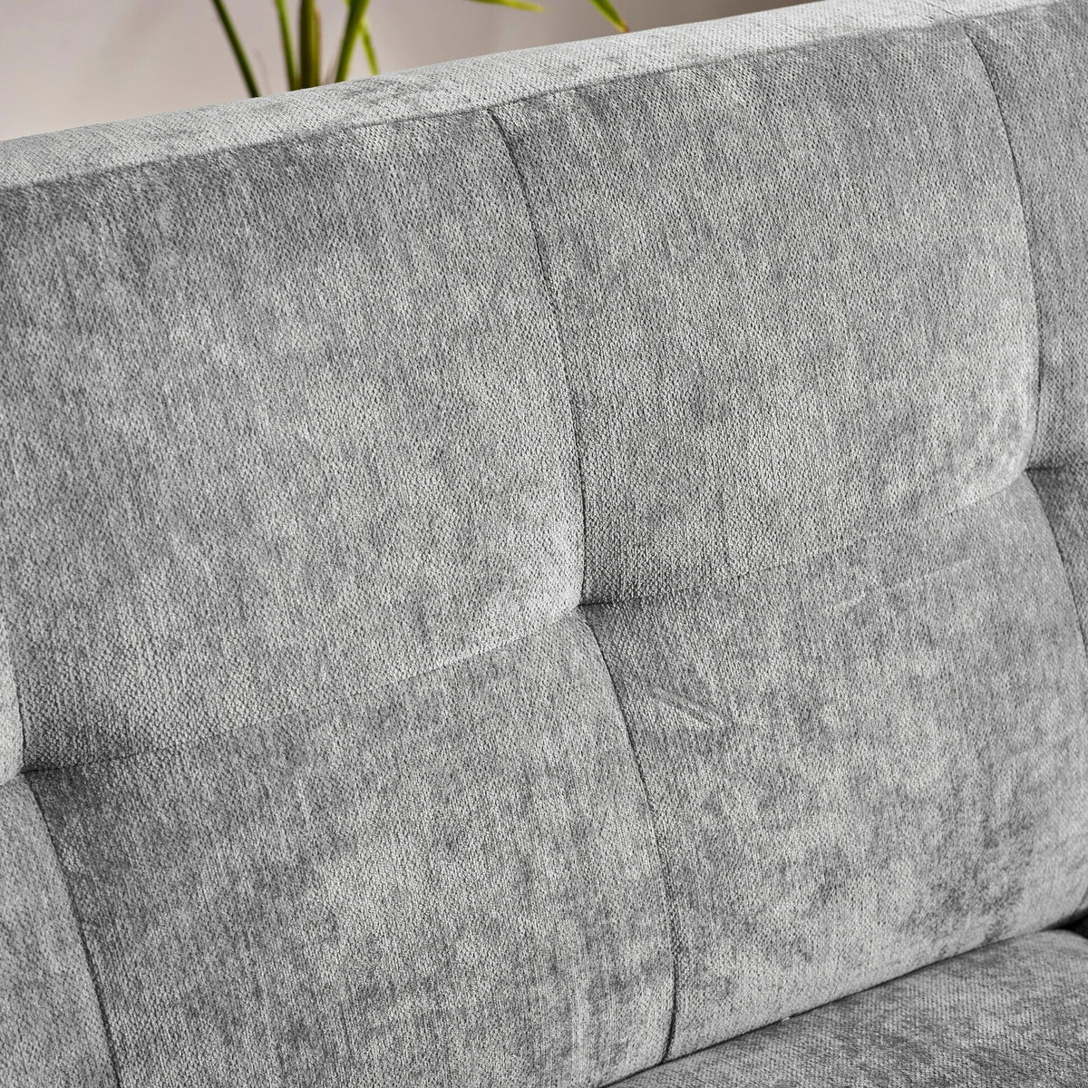 Closeup of grey fabric sofa backrest with stitched tufted detail