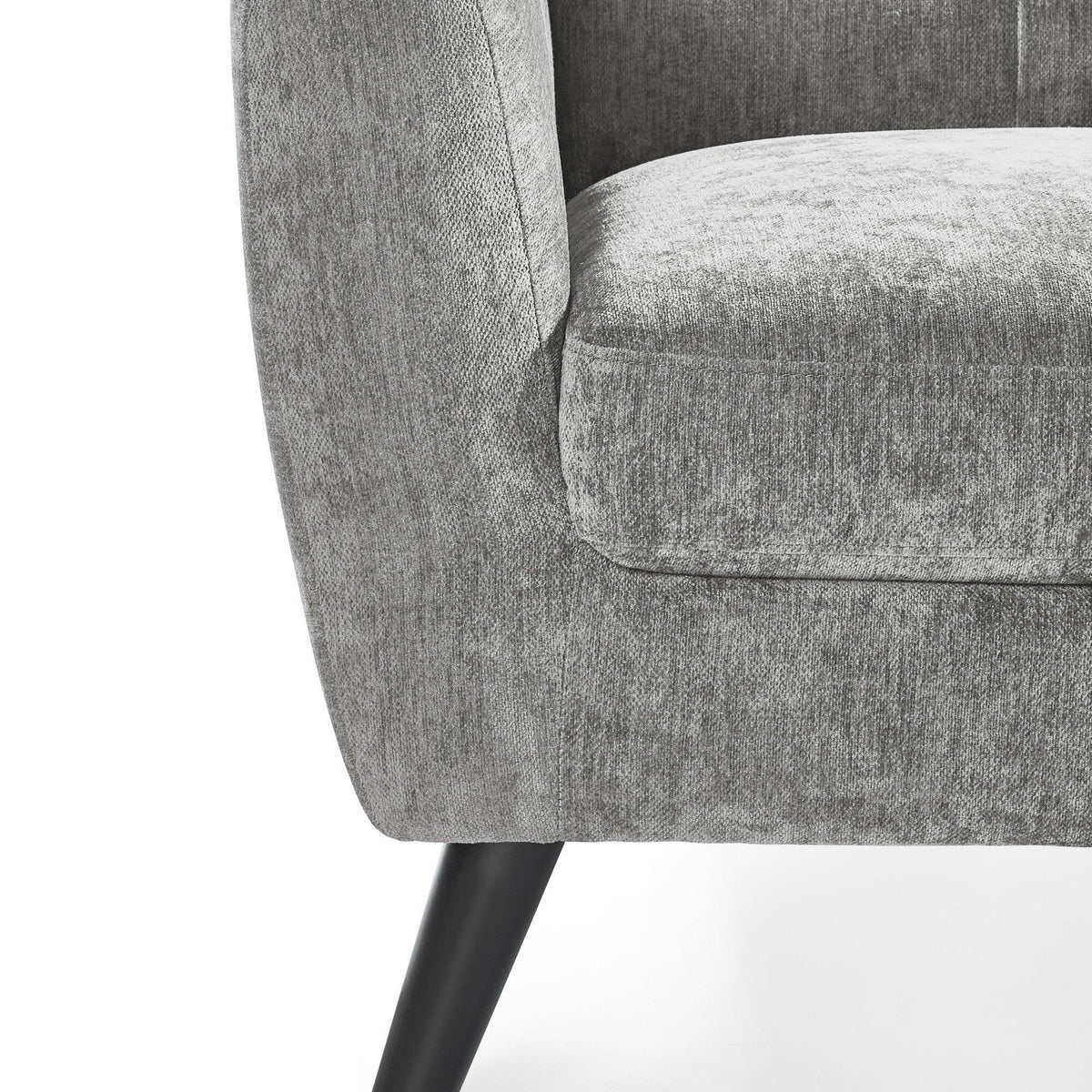 Closeup of grey fabric sofa armrest and cushion with black tapered wooden leg