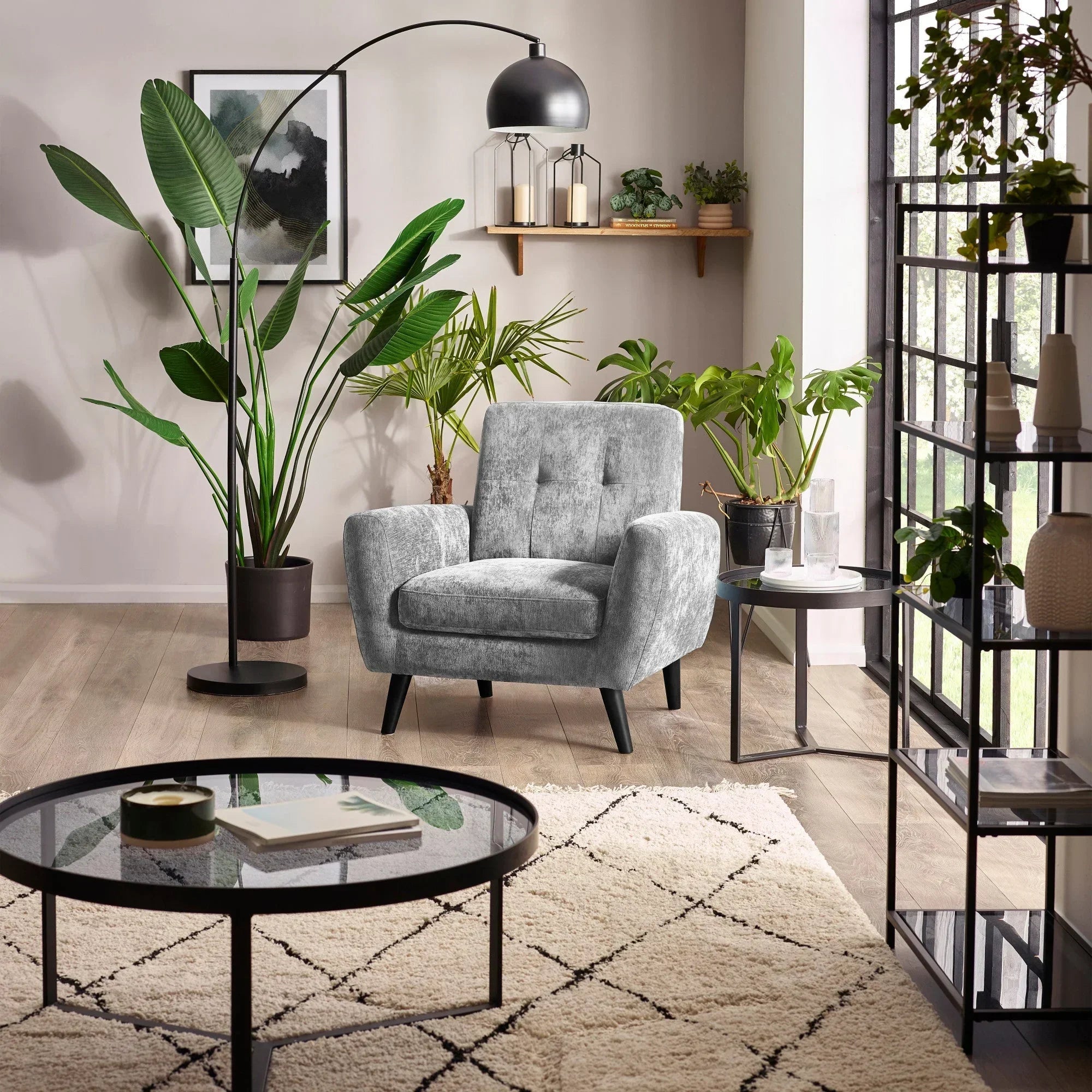 Dove grey armchair with button back in modern living room, surrounded by green plants