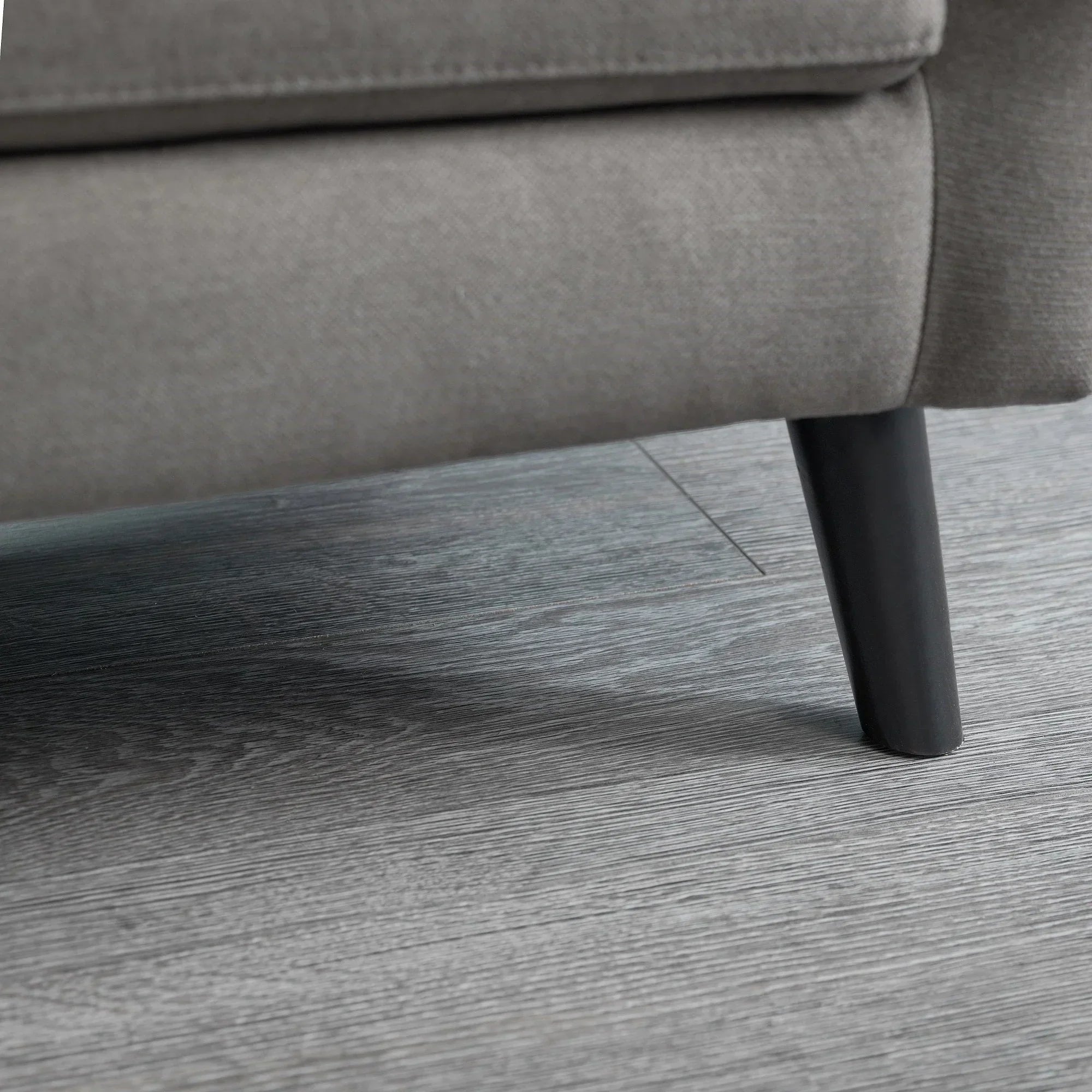 Grey sofabed fabric and black tapered leg detail on wood flooring