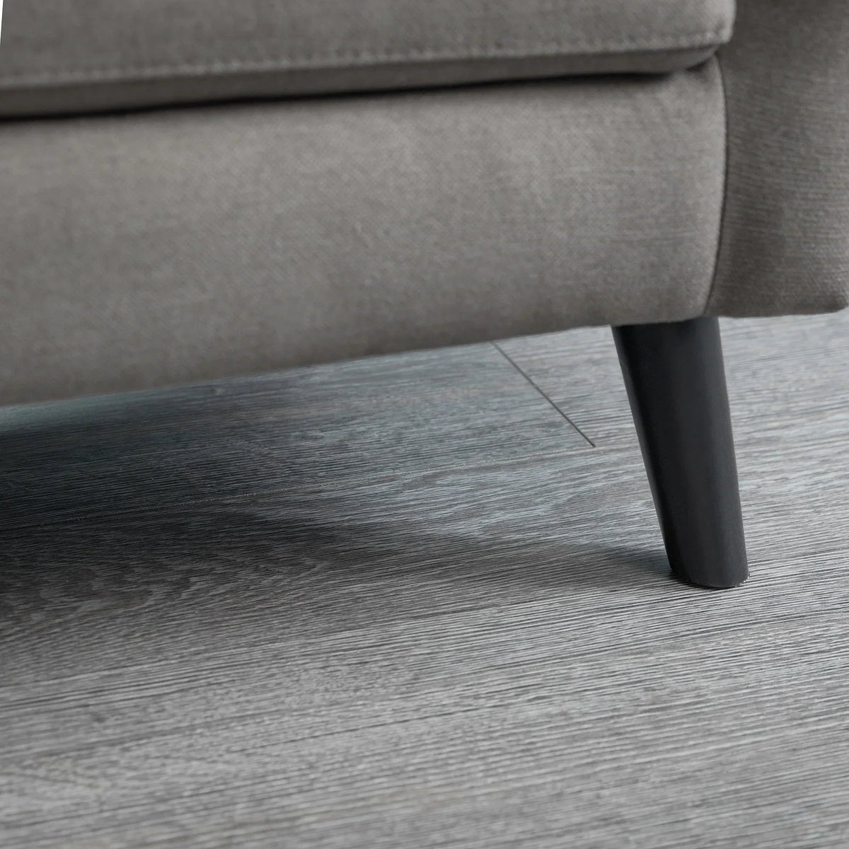 Grey sofabed fabric and black tapered leg detail on wood flooring