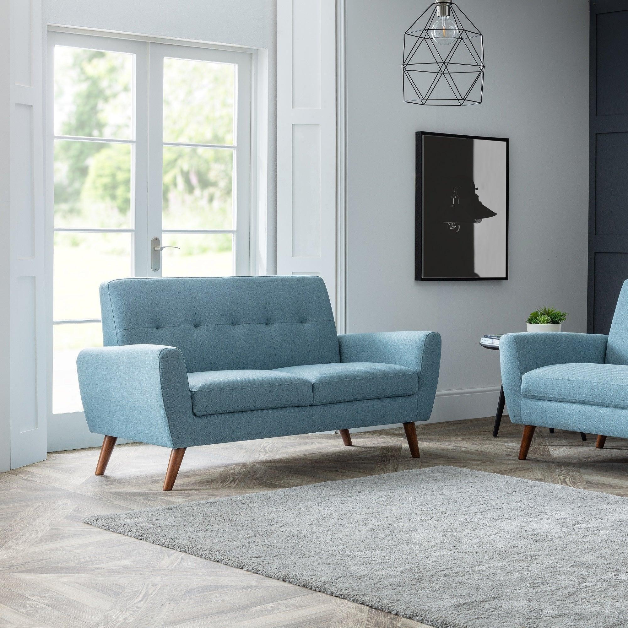 Blue fabric two seater and three seater sofas in modern living room with grey rug