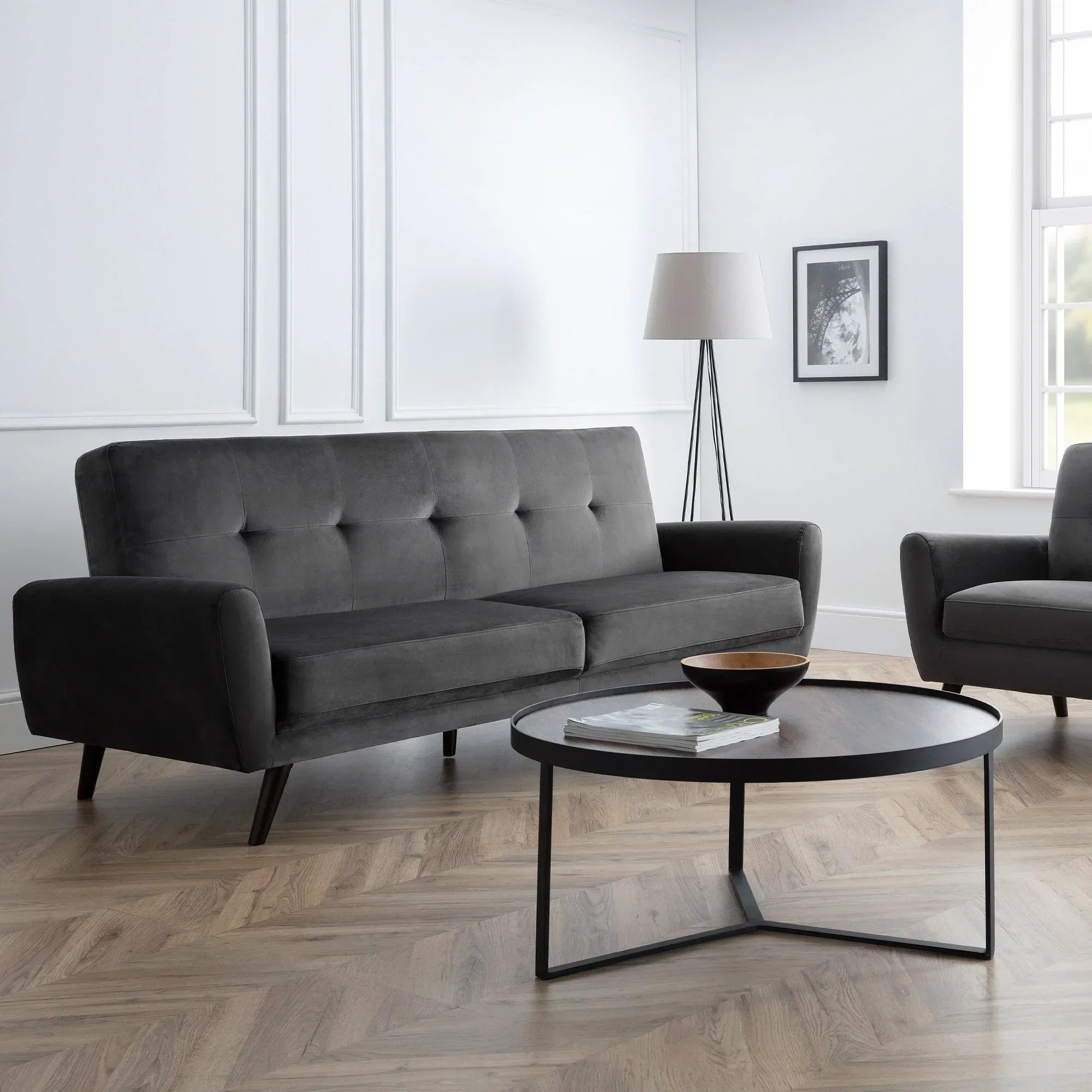 Grey velvet 2 seater sofa with button tufting in modern living room with round coffee table