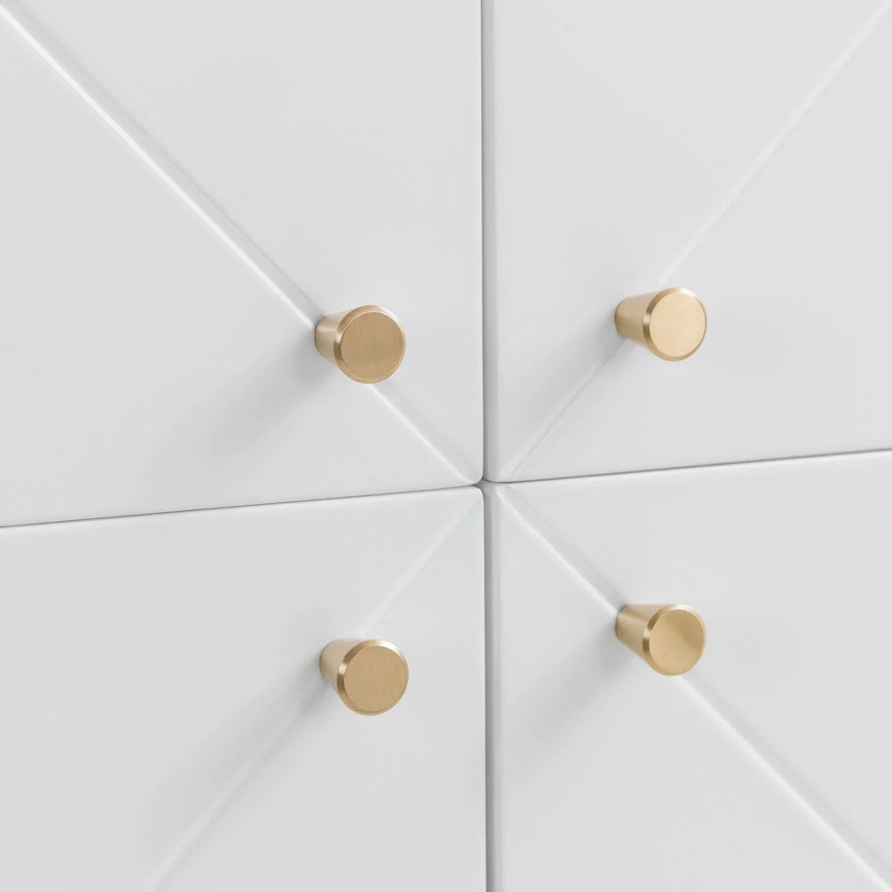 Closeup of white drawer fronts with gold round handles and geometric panel design