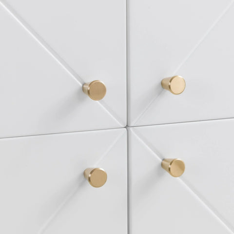 Closeup of white drawer fronts with gold round handles and geometric panel design