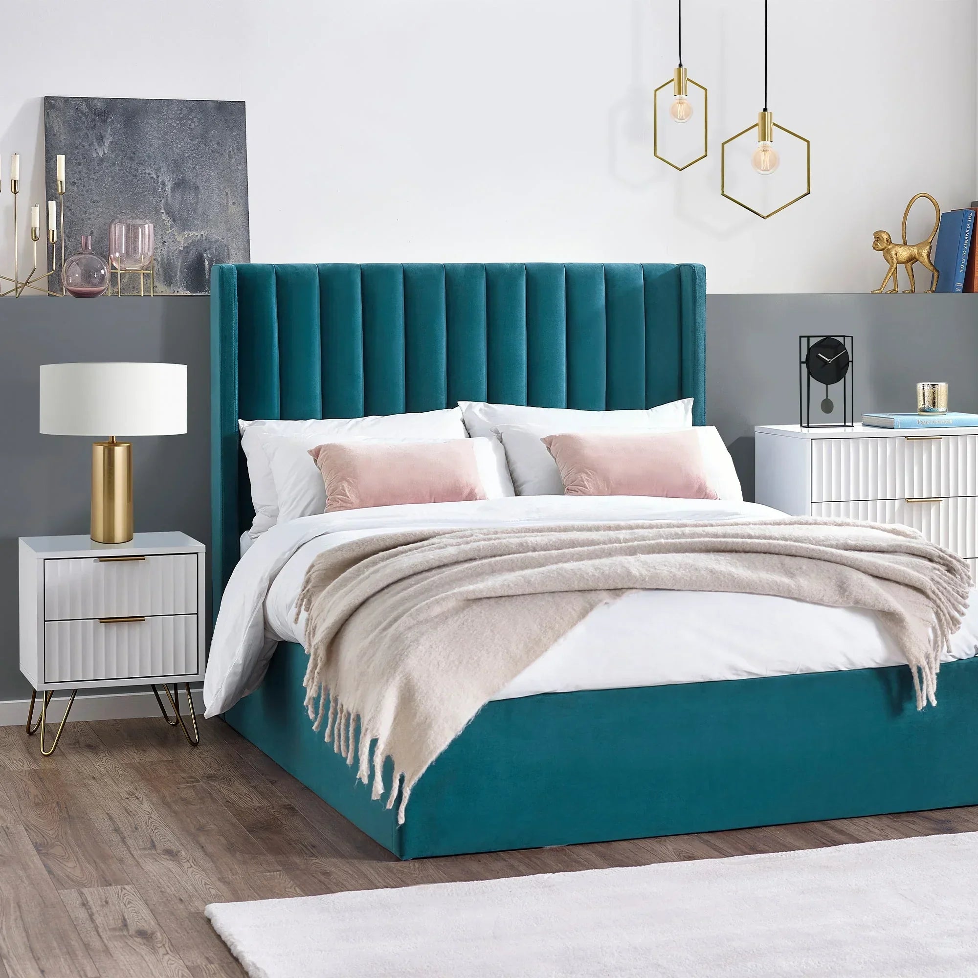 White two-drawer bedside table with gold handles beside teal upholstered bed in modern bedroom