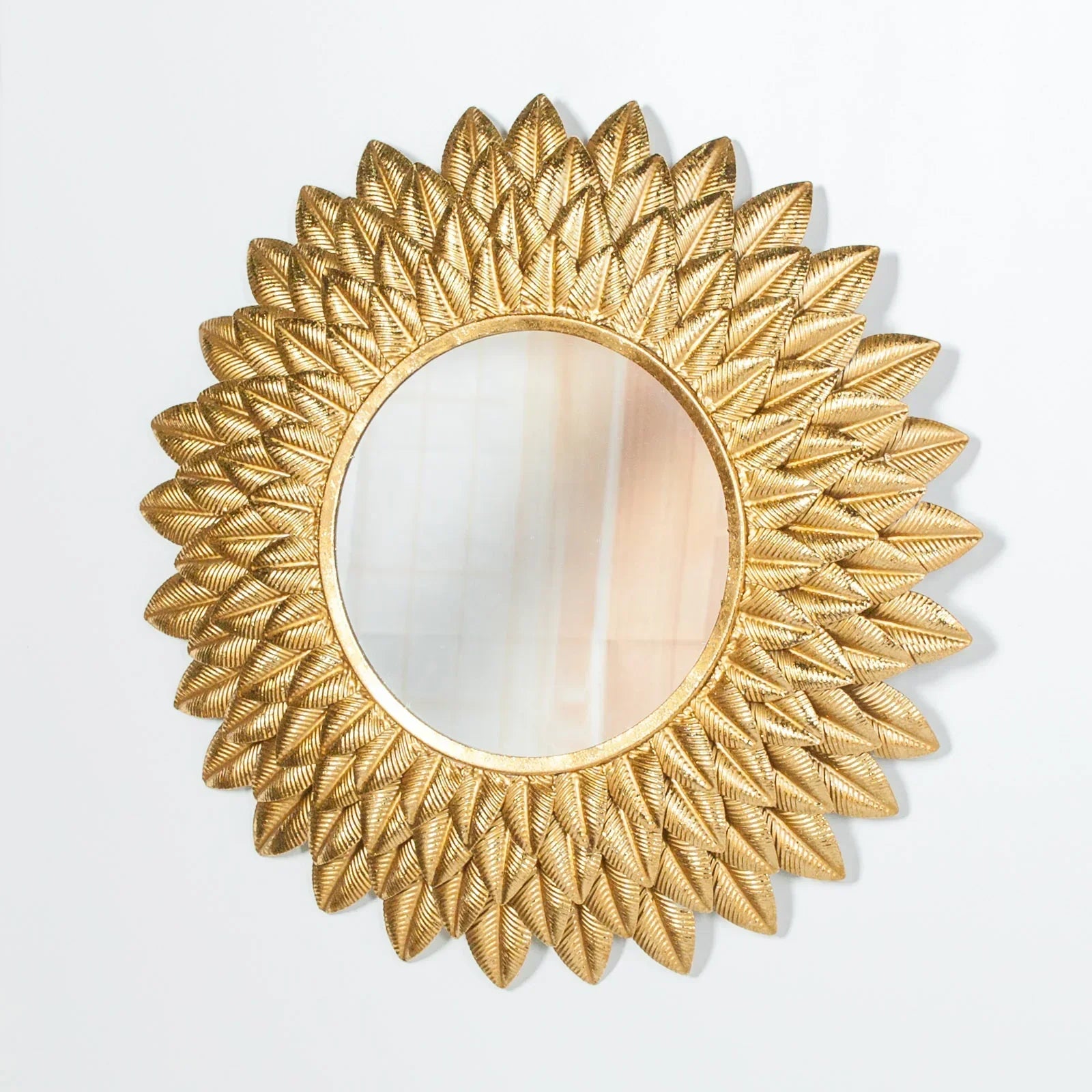Gold sunburst wall mirror with textured leaf pattern frame