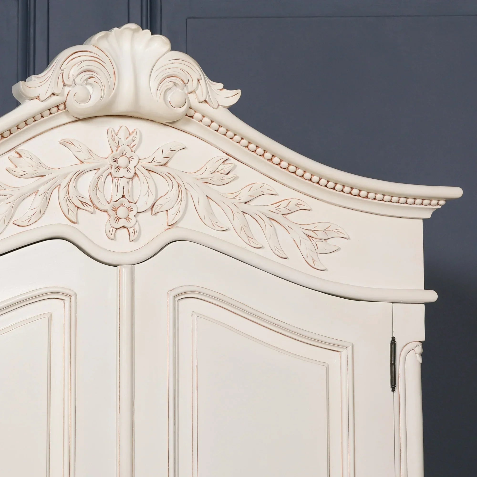 Cream wood wardrobe top with carved floral detailing and curved molding