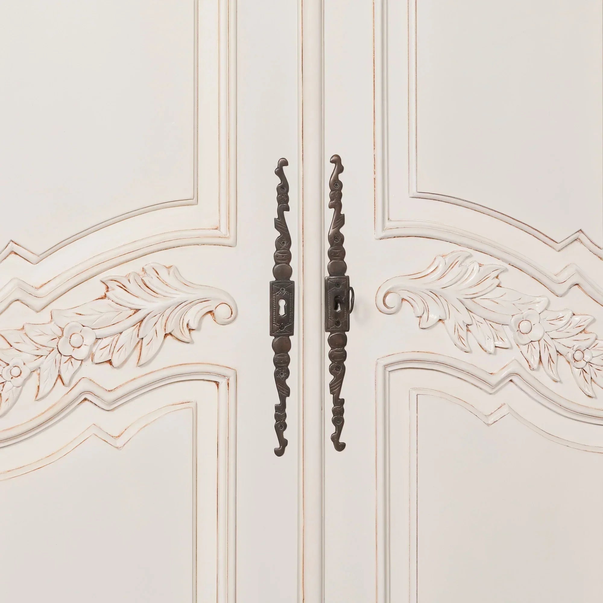 Cream painted wardrobe doors with floral carvings and antique metal handles