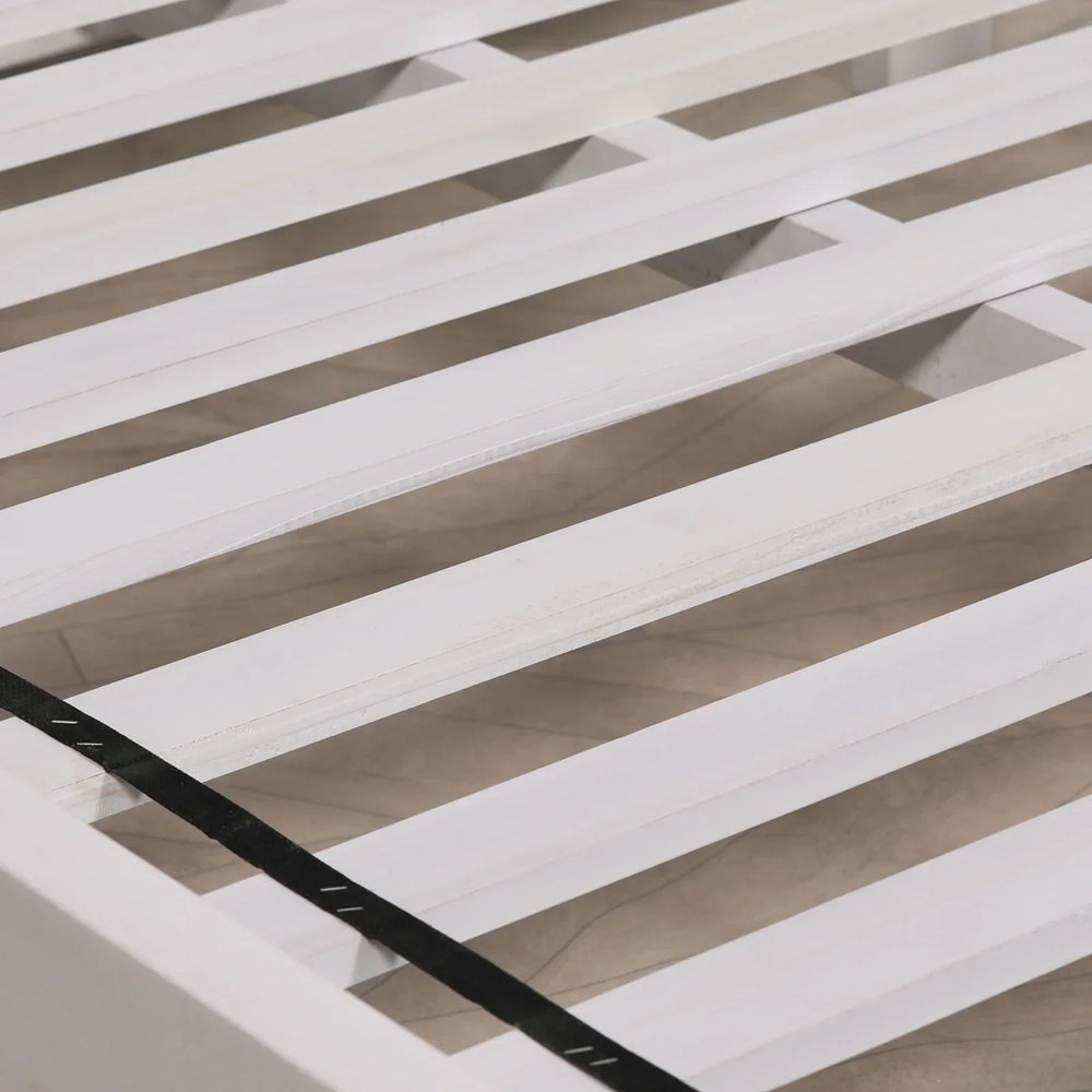 White wooden bed frame slats with black support strap, close-up view