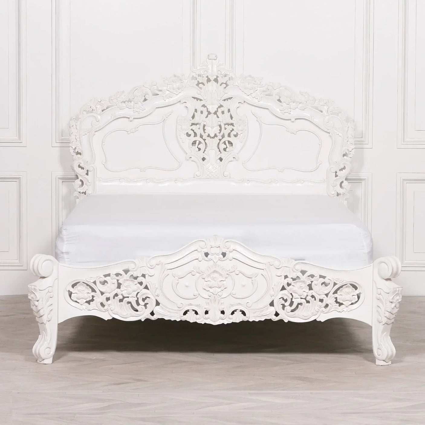 White ornate carved bed frame with intricate headboard and footboard, classic bedroom style